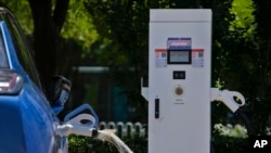 A Chinese electric vehicle charges at an electric vehicle charging station in Beijing, June 24, 2024. 