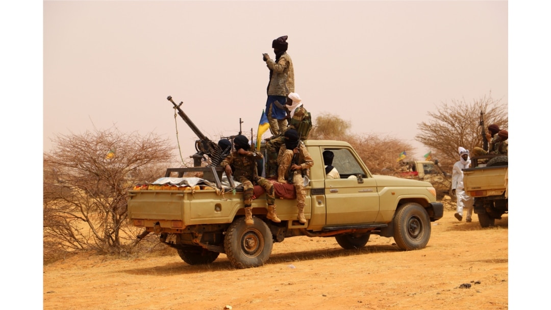 FILE - An anti-aircraft gun is mounted on the back of a pickup truck as militants from a Tuareg political and armed movement in the Azawad Region in Mali gather in the desert outside Menaka, March 14, 2020.