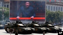 Presiden Xi Jinping tampak pada layar raksasa sementara militer China memamerkan tank tempur jenis 99A2 di gerbang Tiananmen, Beijing, Kamis (3/9). 