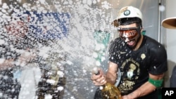 Boston Celtics forward Jayson Tatum sprays champagne while celebrating after defeating the Dallas Mavericks in Game 5 to win the NBA basketball finals June 17, 2024, in Boston.