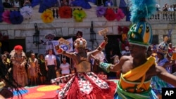 FILE - Performers dance prior to a ceremony that marks the official start of Carnival in Rio de Janeiro, Brazil, February 2024.