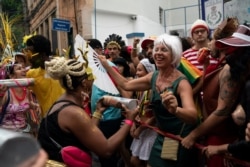 A reveler in a costume enjoys the "Ceu na Terra" or Heaven on Earth street party in Rio de Janeiro, Feb. 22, 2020. From very early in the morning revelers take the streets of the bohemian neighborhood Santa Teresa for one of the many block parties.