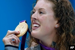 In this July 31, 2012, file photo, United States' Allison Schmitt holds her gold medal after winning the women's 200-meter freestyle swimming final at the Aquatics Centre in the Olympic Park during the 2012 Summer Olympics in London. (AP Photo/Daniel Ochoa De Olza, File)