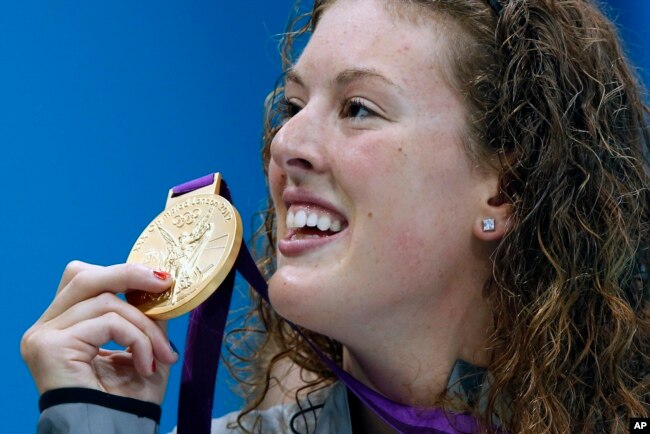 In this July 31, 2012, file photo, United States' Allison Schmitt holds her gold medal after winning the women's 200-meter freestyle swimming final at the Aquatics Centre in the Olympic Park during the 2012 Summer Olympics in London. (AP Photo/Daniel Ochoa De Olza, File)