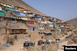 FILE - Houses are seen at a hill in the shanty town Nueva Esperanza on the outskirts of Lima, Peru, March 28, 2018.