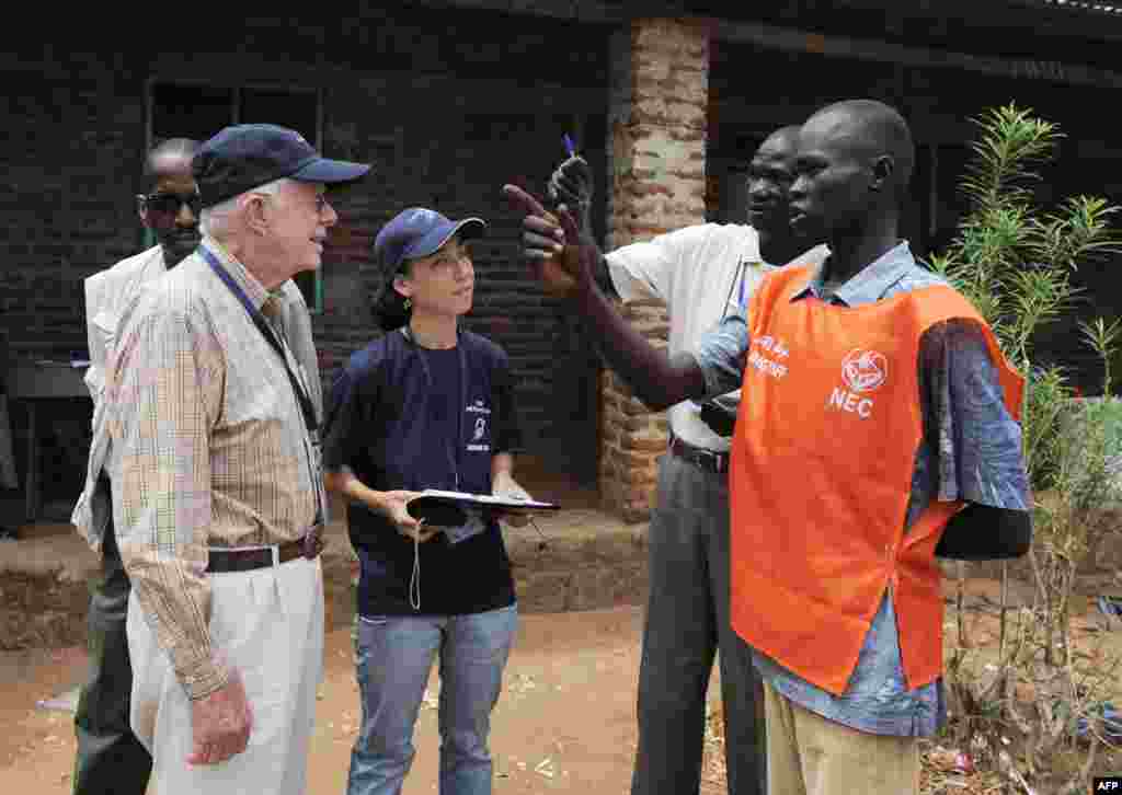 Jimmy Carter (à g) visite des bureaux de vote au sud du Soudan, en tant qu'observateur électoral, le 13 avril 2010. (Photo de Roberto SCHMIDT / AFP)