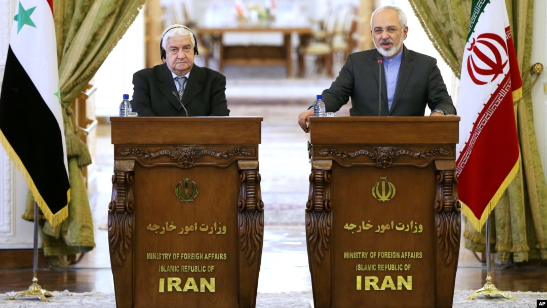 Menlu Suriah Walid Moallem (kiri) dan Menlu Iran Mohammad Javad Zarif mengutuk serangan Israel dalam konferensi pers di Teheran, Senin (8/12).