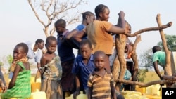 A group of children and adults gather around a bore-hole in the Bidi bidi refugee settlement in Bidi bidi, Uganda, Dec. 10, 2016.