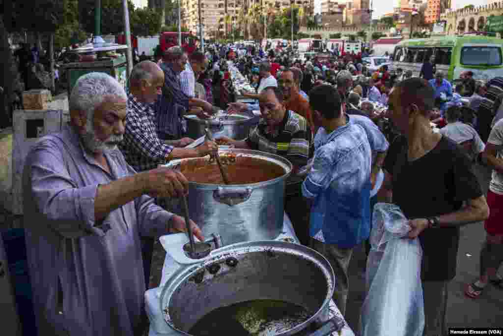 Charitable people distribute food on people coming to attend the prayers at Amru Ebn Alaas mosque in old Cairo, Egypt, June 21, 2017. (Hamada Elrasam/VOA)