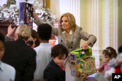 First lady Jill Biden helps sort toys as she hosts a Toys for Tots event with Marine Corps families in the East Room at the White House in Washington, Dec. 13, 2024.