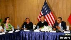 U.S. President Barack Obama speaks toward Myanmar opposition leader Aung San Suu Kyi (L) during a roundtable with members of parliament and civil society to discuss Myanmar's reform process in Naypyitaw, Nov. 13, 2014. 