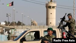 FILE - Afghan National Army (ANA) soldiers keep watch outside the Bagram Airfield entrance gate, north of Kabul, Afghanistan, Nov. 12, 2016.