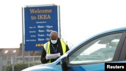 People queue in their cars at an NHS drive-through coronavirus disease (COVID-19) testing facility in the car park of Ikea in Wembley, as the spread of the coronavirus disease (COVID-19) continues, London, April 1, 2020.
