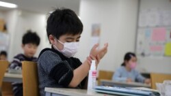 Seorang anak, mengenakan masker wajah pelindung dan menggunakan penyanitasi tangan di "Stella Kids", pusat penitipan anak di Tokyo, Jepang, 5 Maret 2020. (Foto: Reuters/Stoyan Nenov)