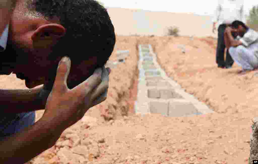 August 25: Libyans mourn during the burial of a rebel fighter killed by Gaddafi  loyalists, in Ben Jawad, Benghazi. REUTERS/Esam Al-Fetori