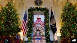 Árboles navideños lucen en la entrada del Cross Hall hacia el Salón Azul de la Casa Blanca, en Washington, el lunes 2 de diciembre de 2024. 