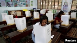 Warga Filipina mengisi surat suara mereka selama pemilihan untuk lebih dari 42.000 pemimpin desa secara nasional di Pasig, Metro Manila di Filipina 14 Mei 2018. (REUTERS/Erik De Castro)