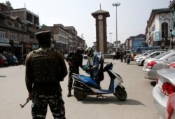 Personil Polisi Cadangan India (CRPF) memeriksa tas pengendara skuter di Srinagar, 12 Oktober 2021. REUTERS/Danish Ismail