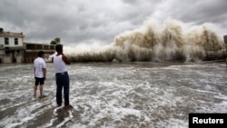 People watch waves hit the shores as Typhoon Usagi approaches in Shantou, Guangdong province, Sept. 22, 2013. 