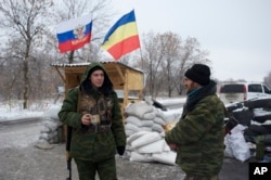 Pro-Russian rebels, cossacks from the 1st Cossack Regiment, guard a checkpoint decorated by Russian national and Don Cossacks flags, just outside in Pervomaisk, eastern Ukraine, Dec. 6, 2014.