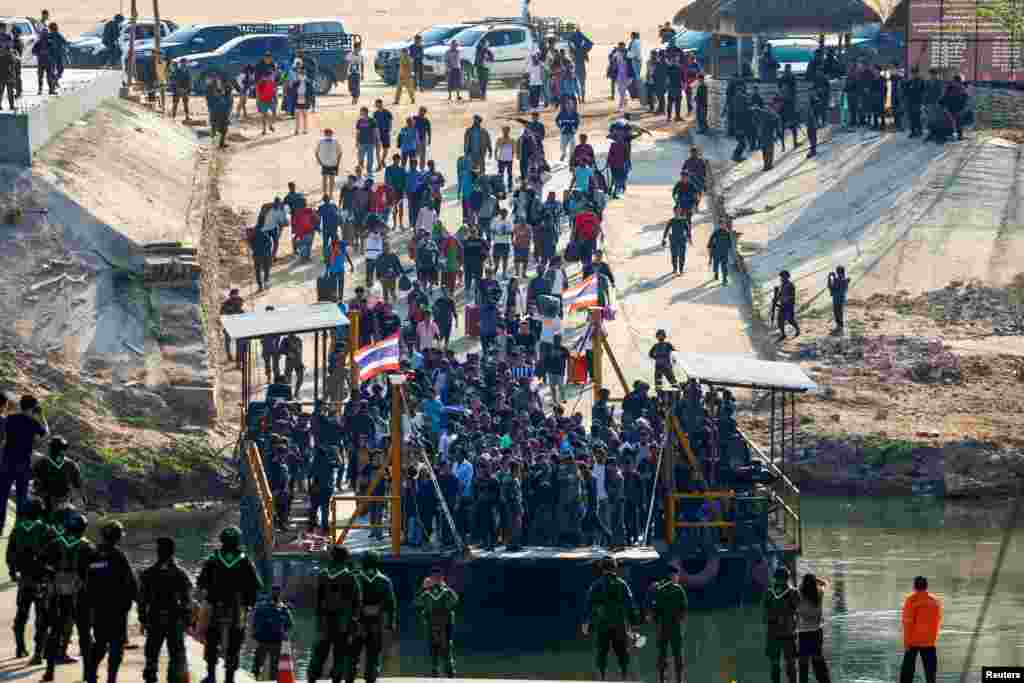 Multinational victims of scam centers, who were tricked or trafficked into working in Myanmar, walk towards a vessel to cross Moei River to Thailand, in Phop Phra District, Tak province, Thailand, Feb. 12, 2025.&nbsp;