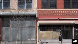 FILE - Two storefronts are empty in New York, April 5, 2021. 