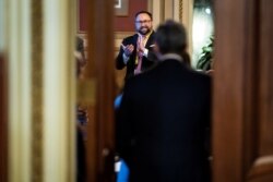 Jason Miller and others clap and cheer as Bruce Castor and Michael van der Veen, lawyers for former President Donald Trump, walk back into their meeting room at the end of the fourth day of the Senate impeachment trials.