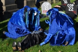 Performers from the Blue Rebels conduct a mock funeral ceremony at the 'Glasgow Necropolis' to symbolize what they see as the failure of the COP26 process, in Glasgow, Scotland, Britain, Nov. 13, 2021.