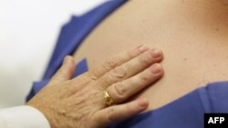 FILE - Dr. Antonella Tost, Dermatologist University of Miami School of Medicine, examines Michael Casa Nova, 12, for symptoms of skin cancer due to sun exposure, June 15, 2011.