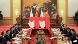 PM Jepang Shinzo Abe (dua dari kanan) berbicara dengan PM China Li Keqiang (dua dari kiri) di Balai Rakyat China, Beijing, China, 26 Oktober 2018. 