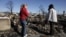 Cathy O'Hanlon, left, looks at the charred remains of her home with a friend in Breezy Point, Queens borough, New York, Nov. 14, 2012.