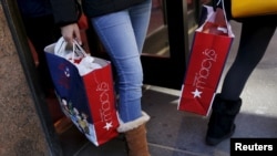 FILE - Shoppers exit Macy's on 34th St. in Herald Square in the Manhattan borough of New York, Nov. 24, 2015. 