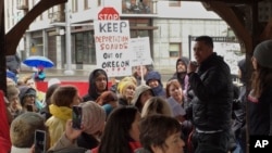 Protesters gather during a rally outside an Immigration and Customs Enforcement office in Portland, Oreron. Federal immigration officers stopped two vans carrying 19 workers headed to a forest in Oregon to pick an ornamental shrub and took 10 of them away, an activist said Tuesday.