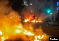 A man stands between bonfires lit by demonstrators as they clashed with police during an anti-government protest in Rio de Janeiro, June 20, 2013.