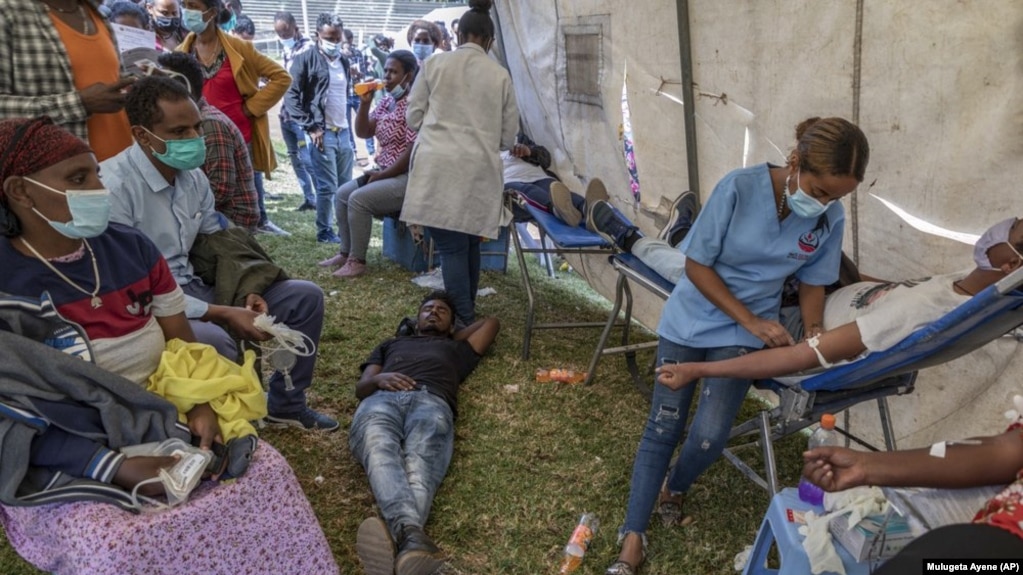 A man lies down after giving blood at a blood drive in support of the country's military, at a stadium in the capital Addis Ababa, Ethiopia Thursday, Nov. 12, 2020. (AP Photo/Mulugeta Ayene)