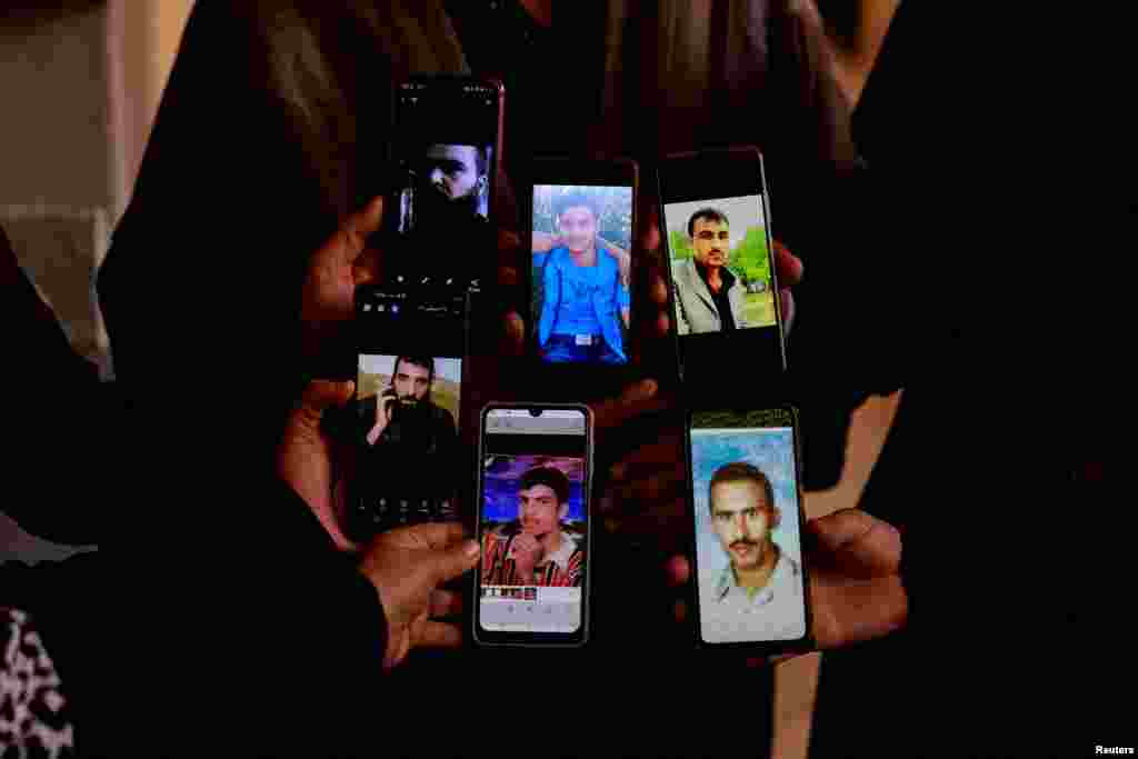 People display the photos of their relatives on mobile phones as they join members of the Syrian civil defense group, known as the White Helmets, in search of prisoners at the Sednaya prison in Sednaya, Dec. 11, 2024.