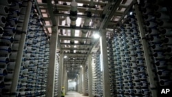 A worker is surrounded by pipes inside a desalination plant in the city of Hadera, Israel, May 16, 2010.