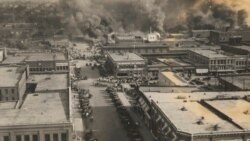 FILE - Crowds of people watch fires during the Tulsa Race Massacre in Tulsa, Okla., on June 1, 1921. (Department of Special Collections, McFarlin Library, The University of Tulsa via AP)