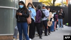 People queue for a COVID-19 test in Melbourne on May 27, 2021 after five million people in Melbourne were ordered into a snap week-long lockdown following another COVID-19 virus outbreak. 