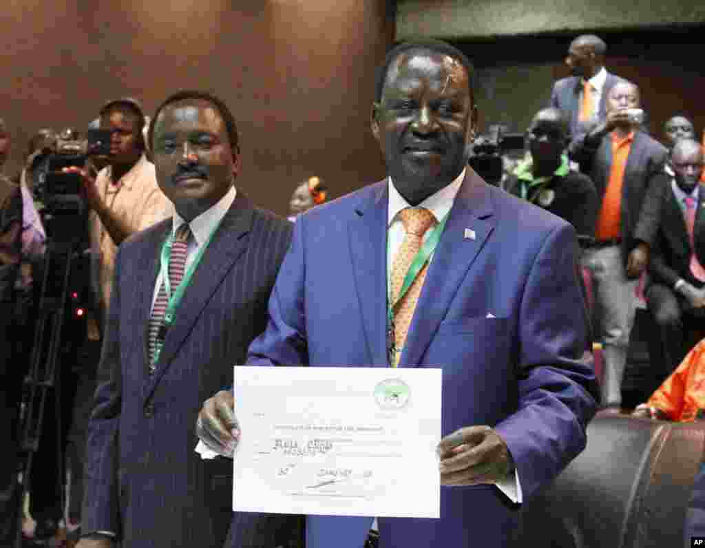 Orange Democratic Party, ODM, presidential candidate, Raila Odinga, right, displays his registration certificate, with running mate Vice President Kalonzo Musyoka, left, in Nairobi, Kenya, Jan. 30. 2013. 