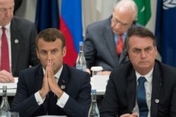 FILE - France's President Emmanuel Macron, left, and Brazil's President Jair Bolsonaro attend a meeting at the G-20 Summit in Osaka, June 28, 2019.