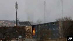 Flames rise from a government building after an explosion and attack by gunmen, in Kabul, Afghanistan, Monday, Dec. 24, 2018. 