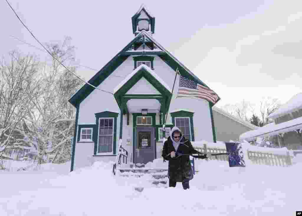 Postal clerk Pamela Bentley shovels snow in front of the U.S. Post Office in Grafton, New York.