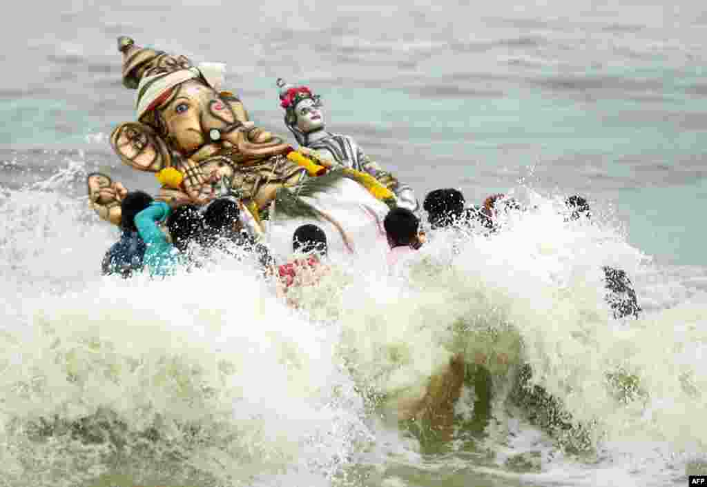 Indian devotees immerse an idol of the elephant-headed Hindu god Ganesh in the Indian ocean at Pattinapakkam beach in Chennai.