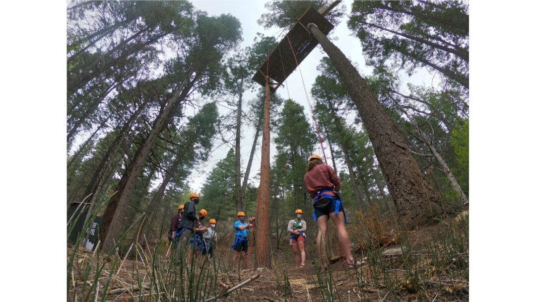Menjelang kedatangan pekemah di bulan Juni, para konselor di Glorieta Adventure Camp berlatih rappelling pohon pada hari Jumat, 21 Mei 2021, di Glorieta, N.M. (AP)