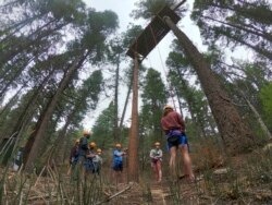 Menjelang kedatangan pekemah di bulan Juni, para konselor di Glorieta Adventure Camp berlatih rappelling pohon pada hari Jumat, 21 Mei 2021, di Glorieta, N.M. (AP)