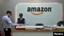 FILE - Security guards stand at the reception desk of the Amazon India office in Bengaluru, India, Aug. 14, 2015. 