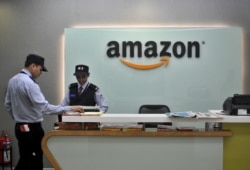 FILE - Security guards stand at the reception desk of the Amazon India office in Bengaluru, India, Aug. 14, 2015.