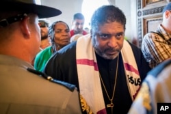 The Reverend William J. Barber argues with state troopers at the doors of the Capitol during a protest organized by the Kentucky Poor People's Campaign in Frankfort, Ky., June 4, 2018. Anti-poverty activists were denied group access to the Capitol following an outdoor rally that included a denunciation of the nation's first work requirements for Medicaid.