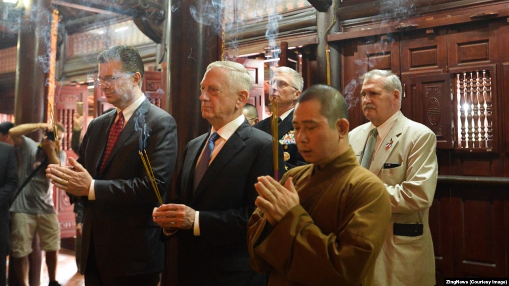 Bộ trưởng Quốc phòng Mỹ (giữa) dâng hương tại chùa Trấn Quốc hôm 25/1. (Ảnh chụp màn hình ZingNews)